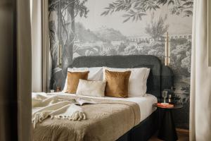 een slaapkamer met een groot bed en een schilderij bij Flo Boutique - LoftAffair Collection in Krakau