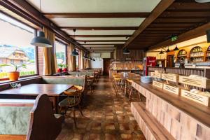 a restaurant with tables and chairs and windows at Pension Tilly in Niederöblarn