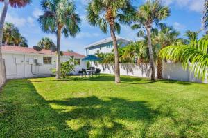 a yard with palm trees and a white house at Gulf Haven in Anna Maria Island