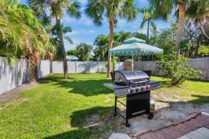 a barbecue grill in a yard with palm trees at Gulf Haven in Anna Maria Island