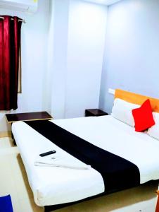 a bedroom with a white bed with red and orange pillows at THE ROYAL STAY In in Hyderabad