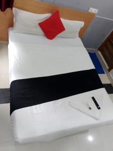 a large white bed with a red pillow and a red at THE ROYAL STAY In in Hyderabad