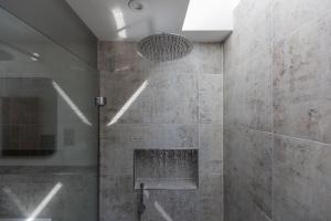 Un baño con ducha con pared de piedra. en Aurora Skies, en Porthtowan 43 fotos más