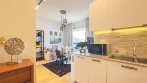 a kitchen with a sink and a living room at Suite Canal Salso by Ca-Sa Check in Mestre +25 photos