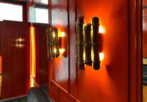 an orange wall with lights on a door at Maison Muse Sablon in Brussels