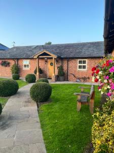 文斯福New Farm Cheshire B&B的院子里带长凳的砖房