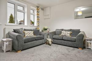 a living room with two couches and a dog in it at North Lincs Cosy Home in Messingham