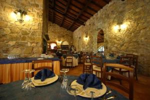 a restaurant with tables and chairs and a stone wall at La Frontiera in San Feliciano
