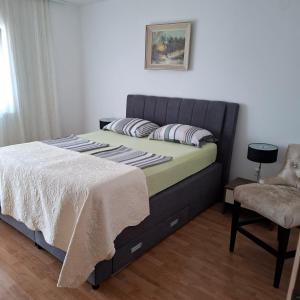 a bedroom with a bed and a chair at Jelly in Crikvenica