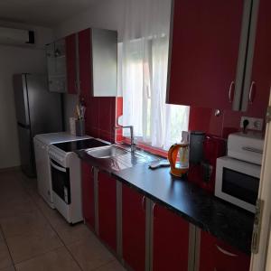 a kitchen with red cabinets and a black counter top at Jelly in Crikvenica