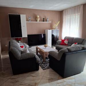a living room with two chairs and a flat screen tv at Jelly in Crikvenica
