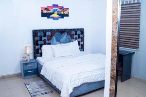 a bedroom with a bed with a headboard and a fireplace at Dee & Dee HOMES in Port Harcourt