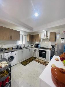 a large kitchen with white appliances and a counter at Ilef in Midoun +6 photos