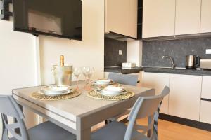 une cuisine avec une table avec des assiettes et des verres à vin dans l'établissement At the Tito Livio Passage - between history and modernity, à Padoue 13 autres photos