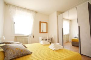 - une chambre avec un lit jaune et un miroir dans l'établissement At the Tito Livio Passage - between history and modernity, à Padoue