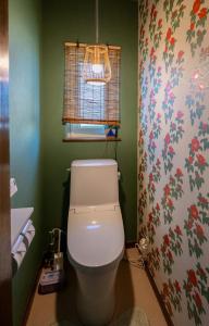a bathroom with a toilet with a flowery wallpaper at sukeemon in Biei +50 photos