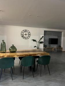 a dining room table with chairs and a clock on the wall at Lugar do Paraíso - Casa do Armazém - Vila do Conde in Touguinho