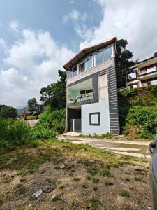 un edificio en la cima de una colina en Euphoria Stays 2BHK in Dehradun, en Dehradun