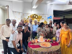 a group of people standing around a table with a cake at DatsunG Studios Near Pune Airport in Pune