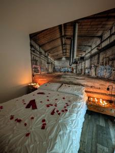 a bedroom with a bed with red roses on it at L'échappée médocaine, deux maisons indépendantes in Cussac-Fort-Medoc