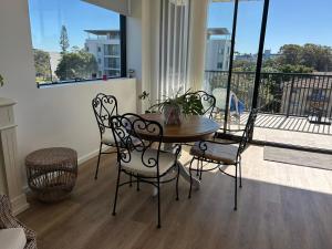 een tafel en stoelen in een kamer met een balkon bij Elite Stay Ladies Only in Port Macquarie +4 foto's