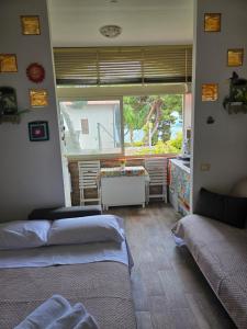 a bedroom with two beds and a table and a window at Chris House Mondello in Palermo +19 photos