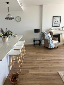 een keuken en een woonkamer met een aanrecht en stoelen bij Elite Stay Ladies Only in Port Macquarie