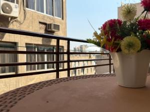 a vase with flowers sitting on a table on a balcony at Velvet Casa - Downtown Cairo in Cairo