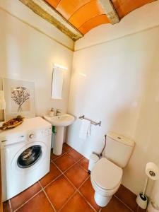 a bathroom with a washing machine and a sink at La casa de la masia in Susqueda