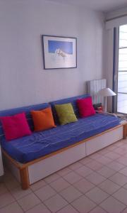 a blue couch with different colored pillows on it at Appartement Figure de proue, près Les Sables d Olonne, Talmont saint Hilaire in Talmont
