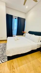 a large white bed in a room with blue curtains at Lucentia Residence Bukit Bintang By Panorama in Bukit Bintang