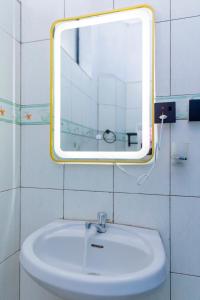 a bathroom with a sink and a mirror on the wall at Deal IN in Gisenyi +21 photos