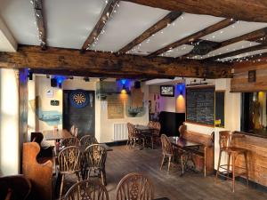 a restaurant with tables and chairs and a bar at Sailors Return Weymouth in Weymouth