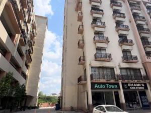 a white car parked in front of a tall building at Luxury 1 BHK Family Apartment in Bahria Town, Islamabad in Rawalpindi