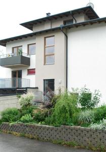 a white house with a stone wall in front of it at Apart Spieljochbahn in Fügenberg +10 photos