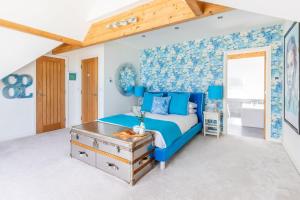 Un dormitorio azul con una cama y una pared azul. en Tides Edge, en Portreath
