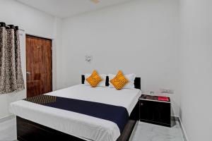 Un dormitorio con una cama grande con almohadas naranjas. en Spot On Tulsi Stay Inn, en Nagpur
