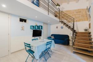a living room with a table and a blue couch at Casa del Golfo in Castellammare del Golfo