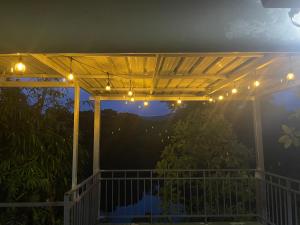 een pergola met verlichting op een terras 's nachts bij โฮมสเตย์ติดแม่น้ำปิง in Sam Ngao
