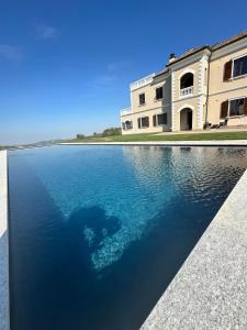 a large pool of water in front of a building at Villa Chloé Boutique Wine Relais in Montecalvo Versiggia