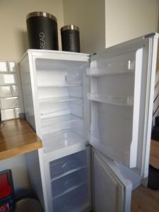 an empty refrigerator with its door open in a room at Taigh Coig in Gairloch