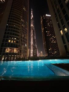 a swimming pool with a view of the shard at night at Private Sea View Room in 3BR Downtown Apartment Direct Mall & Metro Access in Dubai