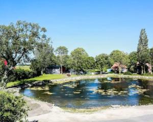 a pond in a park with lilies in the water at Nordic Bliss Cozy Villa with Jacuzzi & Sauna in Nørdstebø 