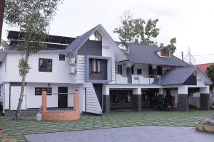 a house with solar panels on the roof at Georges Lakeview Resort in Tiruvalla