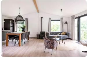 una sala de estar con una mesa y un sofá en De lodge met hottub, en Pingjum