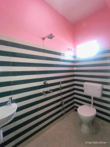 a bathroom with a toilet and a sink at New Projapati Guest House, Prantik Road in Shānti Niketan