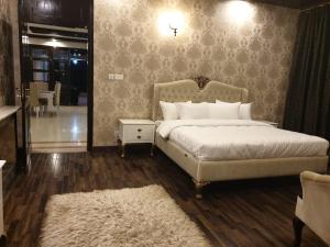 une chambre avec un grand lit et un miroir dans l'établissement Royal Villa Islamabad, à Islamabad