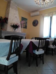 ein Esszimmer mit einem Tisch mit Stühlen und einem Kamin in der Unterkunft Villa Donna Maria in Capoterra