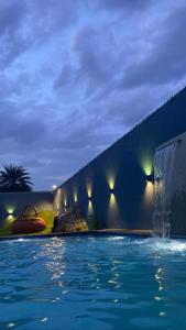 una piscina notturna con fontana di ECR Beach Villa with Private Swimming Pool a Tirupporūr