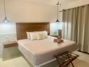 a bedroom with a large bed with a teddy bear on it at Hotel La Casa del Capi in Holbox Island